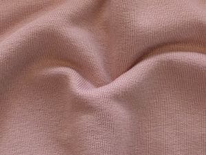 Nahaufnahme des leicht angerauten Sweat-Stoffs in uni Altrosa – ideal für die Herstellung von bequemer Freizeitbekleidung wie Sweatshirts, Hoodies und gemütlichen Oberteilen. Der Stoff bietet eine weiche, angenehme Haptik und sorgt für hohen Tragekomfort.