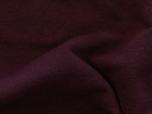 Nahaufnahme des leicht angerauten Sweat-Stoffs in uni Dunkellila – ideal für die Herstellung von Sweatshirts, Hoodies und bequemer Freizeitbekleidung. Der Stoff ist weich, atmungsaktiv und bietet eine angenehme Oberfläche.