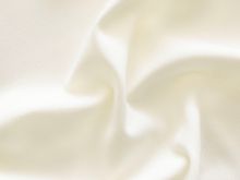 Nahaufnahme von leichtem, hochelastischen Jersey-Stoff in uni Wollweiß – ideal für die Herstellung von T-Shirts, Tops, Leggings und Unterwäsche. Der Stoff ist weich, dehnbar und sorgt für hohen Tragekomfort und Bewegungsfreiheit