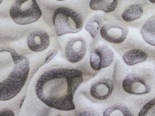 Nahaufnahme von einem kuscheligem Fleece mit Kreisen drauf in grau 