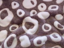 Nahaufnahme von einem kuschligem Fleece mit verschiedenen Kreisen drauf in lila