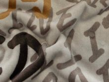 Nahaufnahme von einem kuschligen Fleece in beige mit Schriftzügen 