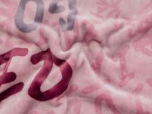 Nahaufnahme von einem kuschligen Fleece in altrosa mit Schriftzügen 